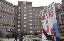 A banner saying "Forza Silvio" (Go Silvio) is seen in front of the San Raffaele hospital, in Milan