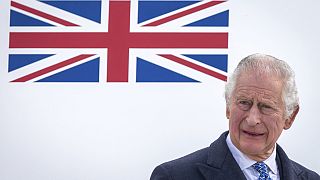 Britain's King Charles III stands in front of the plane after arriving at Berlin Airport in Berlin,