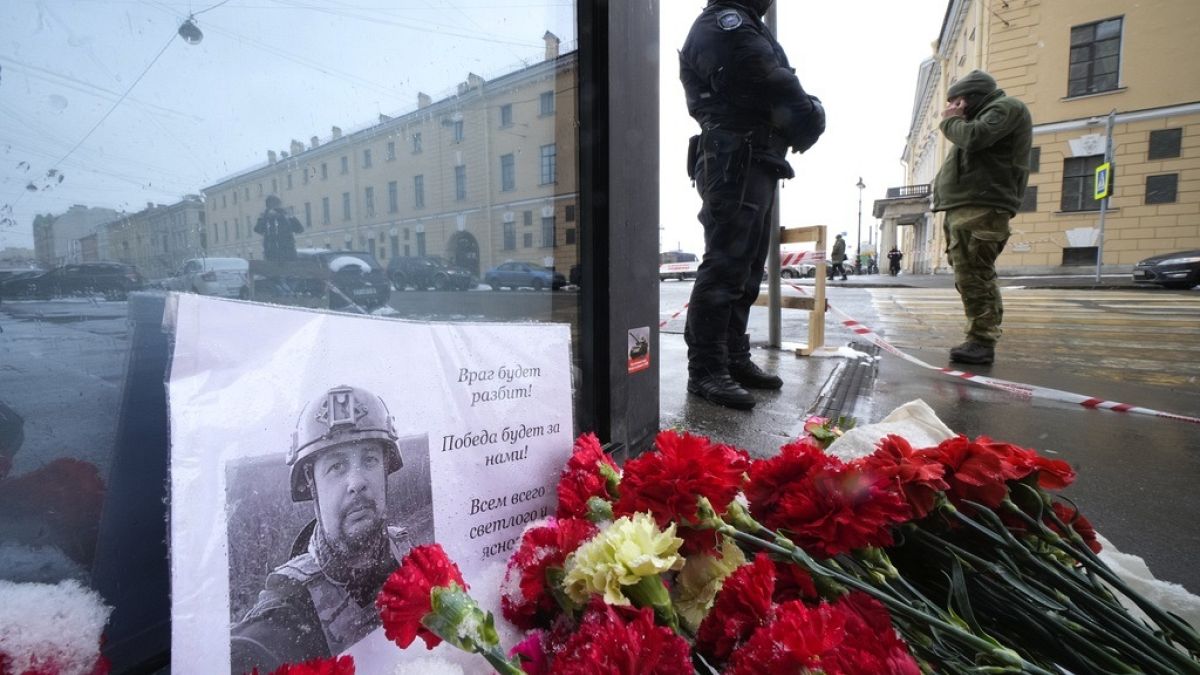 Flowers and a poster with a photo of blogger Vladlen Tatarsky placed near the site of an explosion at the "Street Bar" cafe in St. Petersburg, Russia.