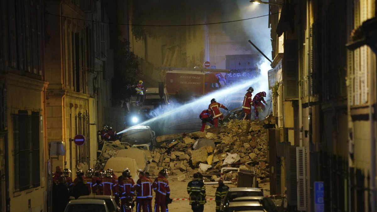 Firefighters gather near the street where a building collapsed early Sunday, April 9, 2023 in Marseille, southern France.