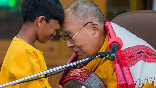 El dalái lama se toca la frente con un niño antes de dirigirse a un grupo de estudiantes en el templo de Tsuglakhang en Dharamshala, India, el 28 de febrero.