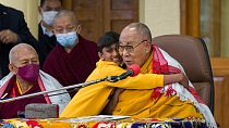Der Dalai Lama neben dem Jungen, der eigentlich nur eine Umarmung wollte