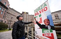 شاب إيطالي يضع لافتة دعم لبرلسكوني أمام مشفى سان رافاييلي