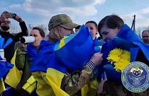 Soldados ucranianos siendo recibidos por sus seres queridos tras el intercambio de prisioneros en Ucrania y Rusia.