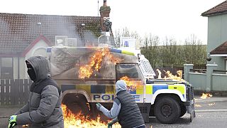 شبان ملثمون يلقون قنابل حارقة على سيارة لاندروفر تابعة للشرطة في لندنديري، أيرلندا الشمالية، الاثنين 10 أبريل 2023.
