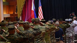 Des soldats américains et philippins saluent leurs drapeaux, à Quezon City, périphérie de Manille, Philippines, le 11 avril 2023