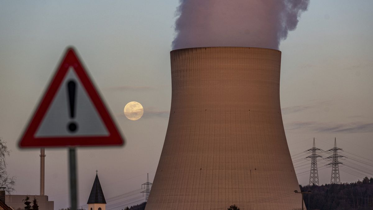 Water vapor rises from the cooling chamber of the Isar 2 nuclear power plant behind a warning sign, in Essenbach, Germany, Wednesday. April 5, 2023
