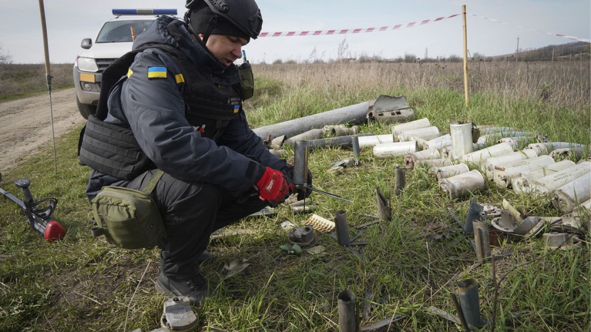 Un zapador del Servicio Estatal de Emergencias de Ucrania recoge restos de proyectiles, granadas y otros artefactos en el lugar de desminado cerca de la aldea de Kamenka