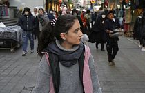 Egy fiatal iráni nő hidzsáb nélkül sétál Teherán utcáin