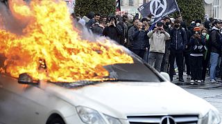 Protesters watch a burning car during a demonstration in Rennes, western France.