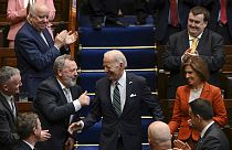 Members of parliament stand as President Joe Biden walks down the steps before he addresses members of the Irish parliament at Leinster House in Dublin, Thursday, April 13.