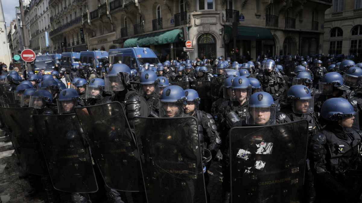 Riot police officers take position during a demonstration, Thursday, April 13, 2023 in Paris.