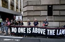 متظاهرون يرفعون لافتة تحمل عبارة: "لا أحد فوق القانون" في نيويورك في إشارة إلى محاكمة ترامب. 2023/04/13