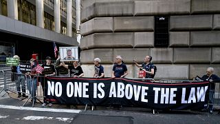 متظاهرون يرفعون لافتة تحمل عبارة: "لا أحد فوق القانون" في نيويورك في إشارة إلى محاكمة ترامب. 2023/04/13