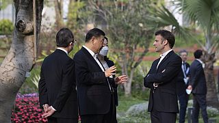 Conversa num jardim, na China, entre os presidentes chinês, Xi Jinping, e francês, Emmanuel Macron 