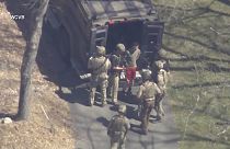 This image made from video provided by WCVB-TV, shows Jack Teixeira, in T-shirt and shorts, being taken into custody by armed tactical agents on Thursday, April 13, 2023, in D