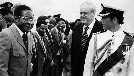 Britain's Prince Charles, right, shares a word with Zimbabwean Prime Minister Robert Mugabe