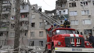 Firefighters work to extinguish a fire as they look for potential victims after today Russian rocket attack in Sloviansk, Donetsk region, Ukraine, Friday, Apr. 14, 2023