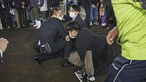 Un homme, au sol, est interpellé à Wakayama, dans l'ouest du Japon, le samedi 15 avril 2023.