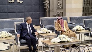   نائب وزير الخارجية السعودي وليد الخريجي، إلى اليمين، يلتقي بوزير الخارجية السوري فيصل المقداد، فور وصوله إلى مطار الملك عبد العزيز الدولي، في جدة، السعودية، 12 نيسان.