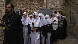 Orthodox Christians clergy and nuns hold candles as they arrive for the Holy Fire ceremony, a day before Easter, at the Church of the Holy Sepulcher