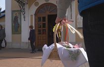 Close-up person holding easter basket filled with eggs, outside the church