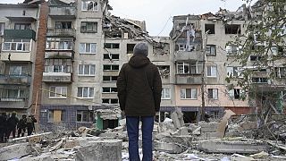 Um homem olha para a sua casa destruída por um ataque com um míssil russo