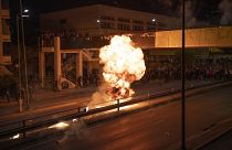 Onlookers watch a petrol bomb explode during celebrations for the Orthodox Easter in Athens, Greece, Sunday, April 16, 2023