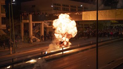 Onlookers watch a petrol bomb explode during celebrations for the Orthodox Easter in Athens, Greece, Sunday, April 16, 2023