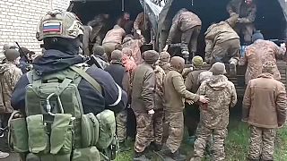 أسرى أوكرانيون خلال صعودهم في شاحنات مجموعة فاغنر