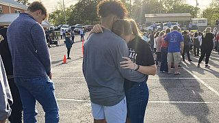 Dos adolescentes se abrazan durante la vigilia por las víctimas del tiroteo de Dadeville