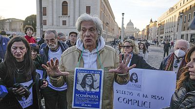 FILE - Pietro Orlandi wears a placard with a picture of his sister Emanuela during a sit-in near Saint Peter's Basilica, in Rome, Saturday, Jan. 14, 2023. 