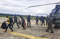 Indonéz rendőrök és katonák kísérik a kiszabadított utasokat Timika repülőterén 2023. február 8-án.
