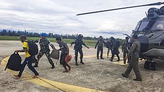 Indonéz rendőrök és katonák kísérik a kiszabadított utasokat Timika repülőterén 2023. február 8-án.