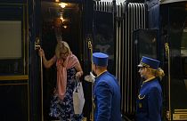 An employee hers a passenger disembark from the Venice Simplon-Orient-Express at Istanbul Station.