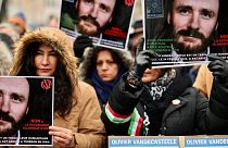 أشخاص يحملون لافتات تطالب بالإفراج عن عامل الإغاثة البلجيكي أوليفييه فانديكاستيل، المحتجز حاليًا في إيران، خلال مظاهرة في بروكسل، الأحد، 22 يناير/كانون الثاني 2023.