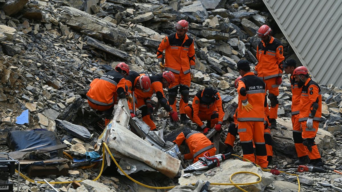 Rescue workers searching inside damaged container after landslide at Pakistan-Afghanistan border crossing on Tuesday.