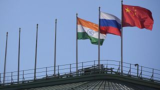 The flags of India, Russia and China flutter on the roof of a hotel with the flags of other countries removed, in central St. Petersburg, Russia.
