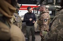 Ein ukrainischer Soldat im Gespräch mit Präsident Wolodymyr Selenskyj