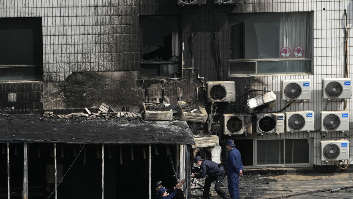 Investigators inspect burnt out corridor following a fire at a hospital in Beijing, Wednesday, April 19, 2023. 