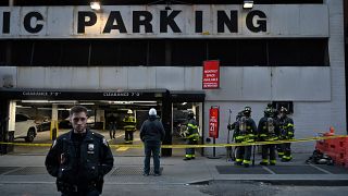 Members of the Fire Department of New York (FDNY) and New York Police Department (NYPD) work at the scene of a parking garage that collapsed in lower Manhattan, New York City,