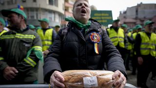 A woman holds a loaf of bread during a farmers' protest in front of the Representative Office of the European Commission in Bucharest, Romania, on, April 7, 2023. 