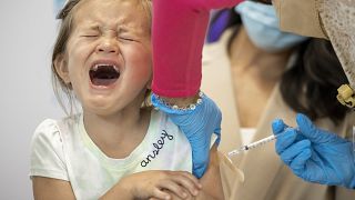 Una niña de cuatro años llora mientras le administran una vacuna COVID-19 en el brazo en el Hospital Infantil de Nueva Orleans, el martes 21 de junio de 2022