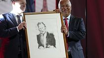 German Chancellor Olaf Scholz, left, presents Portuguese Prime Minister and Socialist Party Secretary General Antonio with a portrait of Willy Brandt.