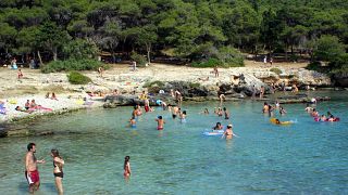 People go for a dip in the clear waters of the Portoselvaggio cove,  in southern Italy's Puglia region, near Lecce, Friday April 20, 2007.