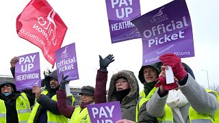 Members of the Unite union stand at a picket line near Heathrow Airport in London.