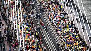 Participants run across the Erasmus Bridge during the 42nd edition of the Rotterdam Marathon on April 16, 2023