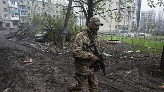 Ukrán katona a szétlőtt Bahmut városában