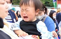 A crying child in Japan prepares for his battle in the crying sumo competition