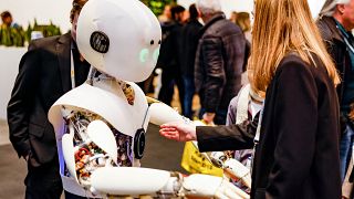 امرأة تتفاعل مع روبوت في معرض هانوفر للتكنولوجيا  في 17 أبريل 2023.